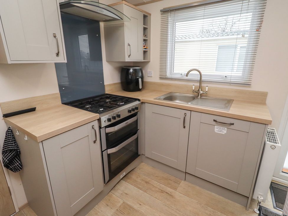 A kitchen with cabinets, a gas stove, and a sink at Cresswell Towers