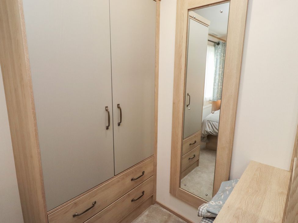 A wardrobe and mirror in a bedroom at Cresswell Towers