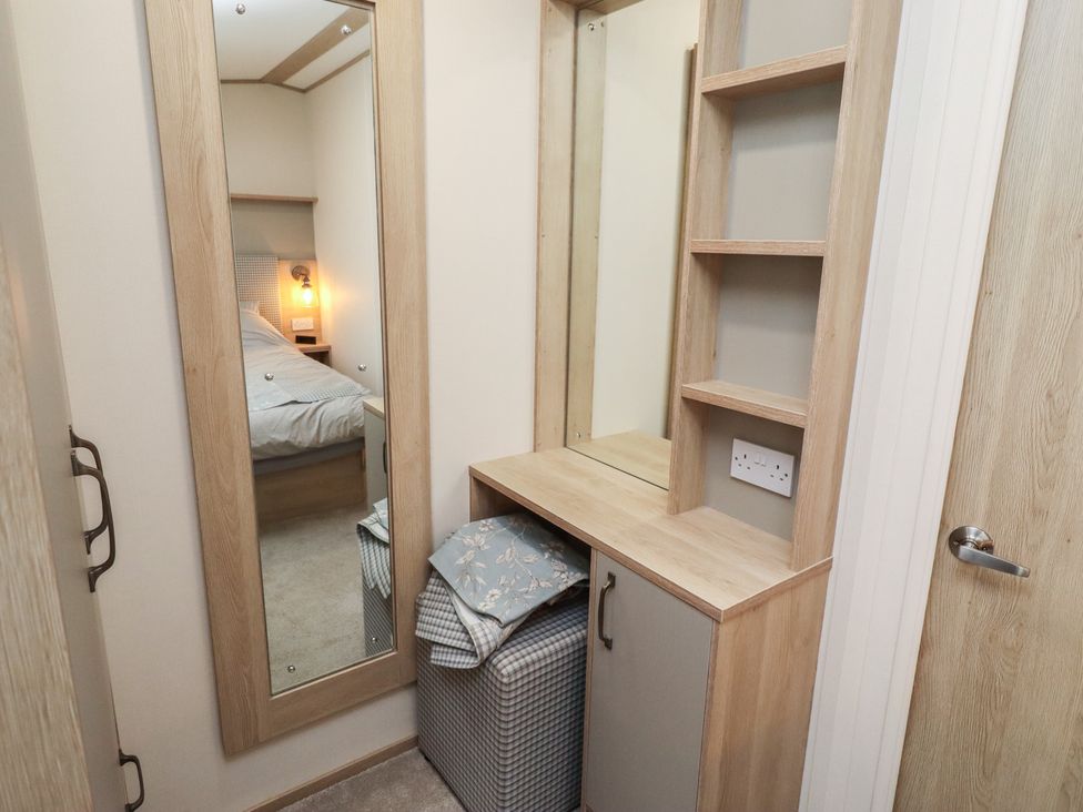 A bedroom with a mirror and storage furniture at Cresswell Towers