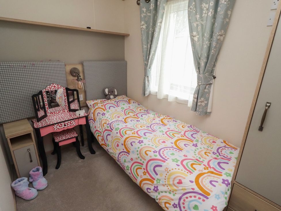 A bedroom with a bed and a vanity table at Cresswell Towers