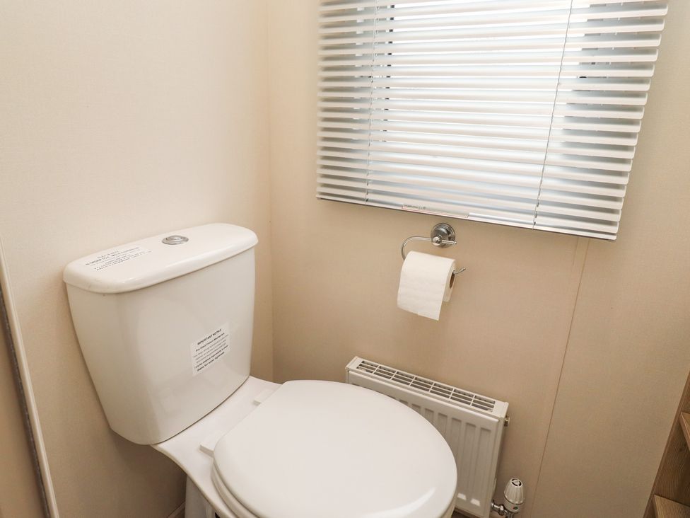 A bathroom with a toilet and window at Cresswell Towers