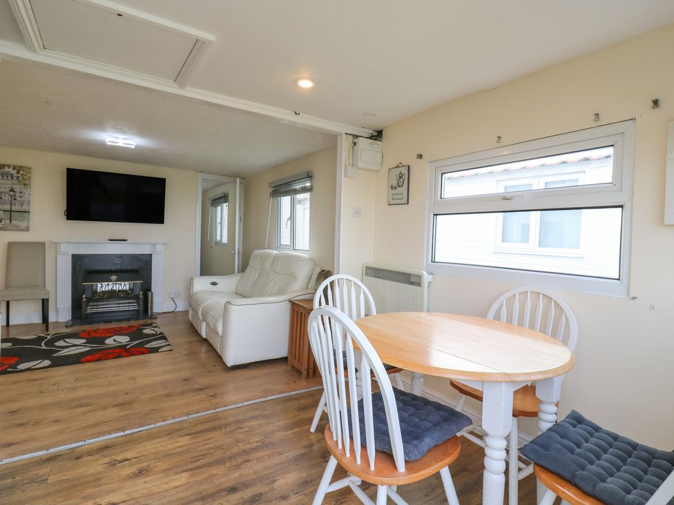 A living room with a tv, sofa, and dining table at 130 Park Ave Holiday Village