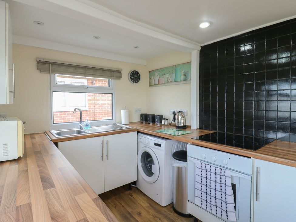 A kitchen with appliances including a sink, washing machine, and oven at 130 Park Ave Holiday Village