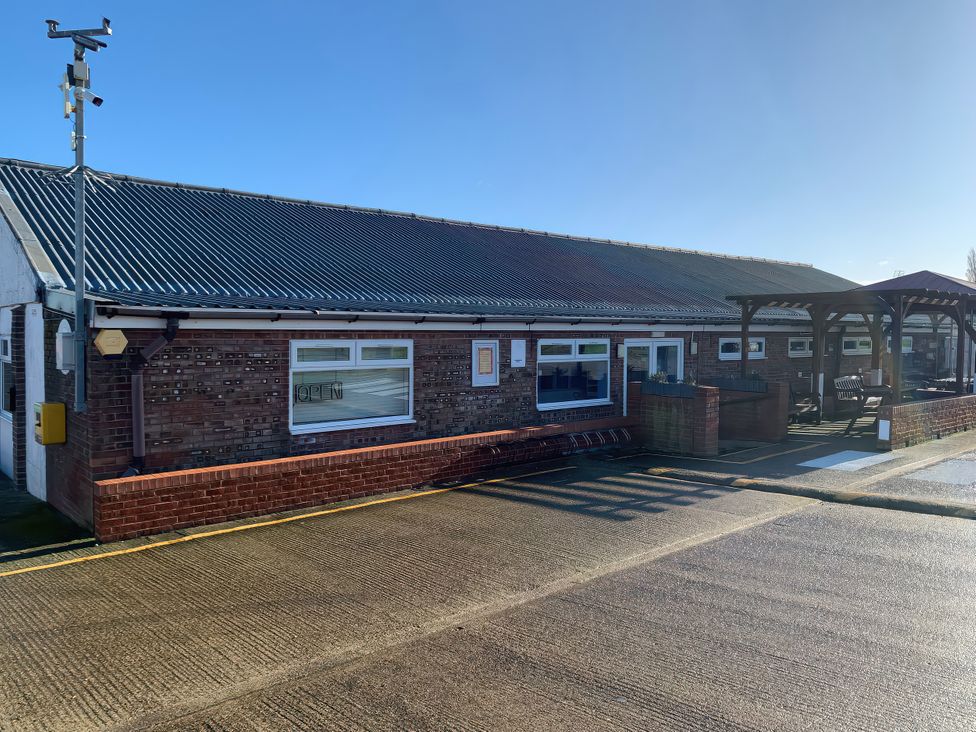 An outdoor area with benches and a sign at Salt Air 130 @ Park Ave Holiday Village, Leysdown-On-Sea, Kent