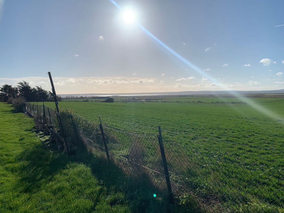 A view of a field and fence under a clear sky at Salt Air 130 @ Park Ave Holiday Village, Leysdown-On-Sea, Kent