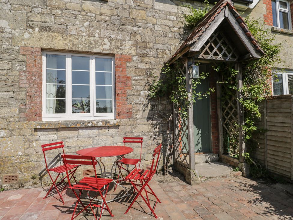 An outdoor space with a red table and chairs at Middle Cottage Tisbury, Wiltshire
