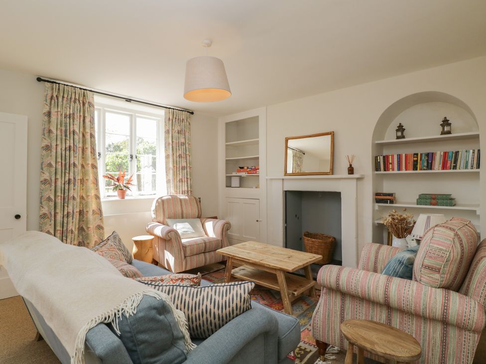 A living room with furniture and a bookshelf at Middle Cottage Tisbury, Wiltshire