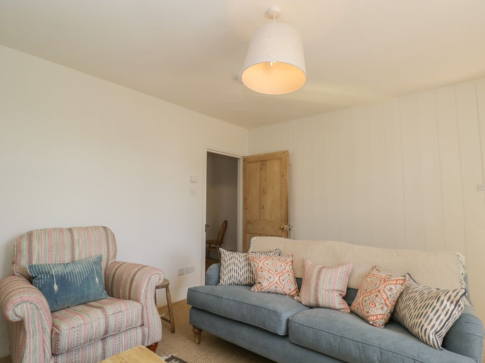 A living room with an armchair and sofa at Middle Cottage Tisbury, Wiltshire