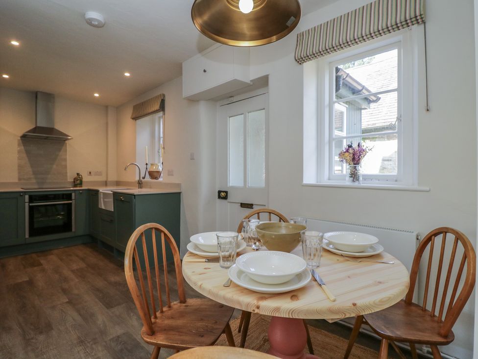 A kitchen with a dining area featuring a round table and chairs at Middle Cottage in Tisbury, Wiltshire