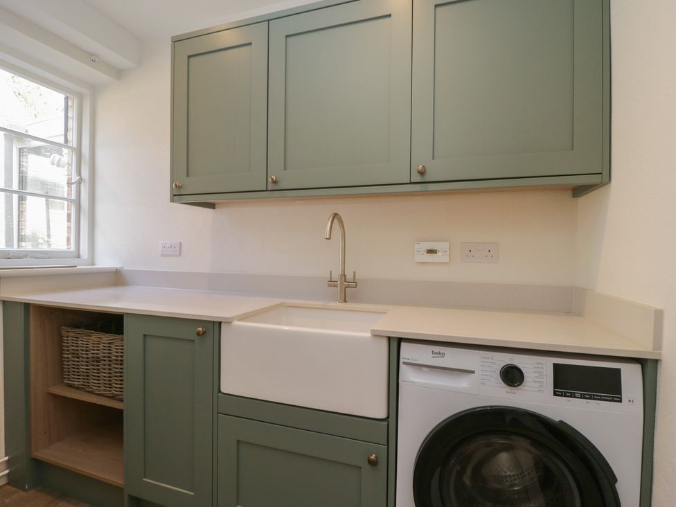 A kitchen with a sink and washing machine at Middle Cottage, Tisbury, Wiltshire