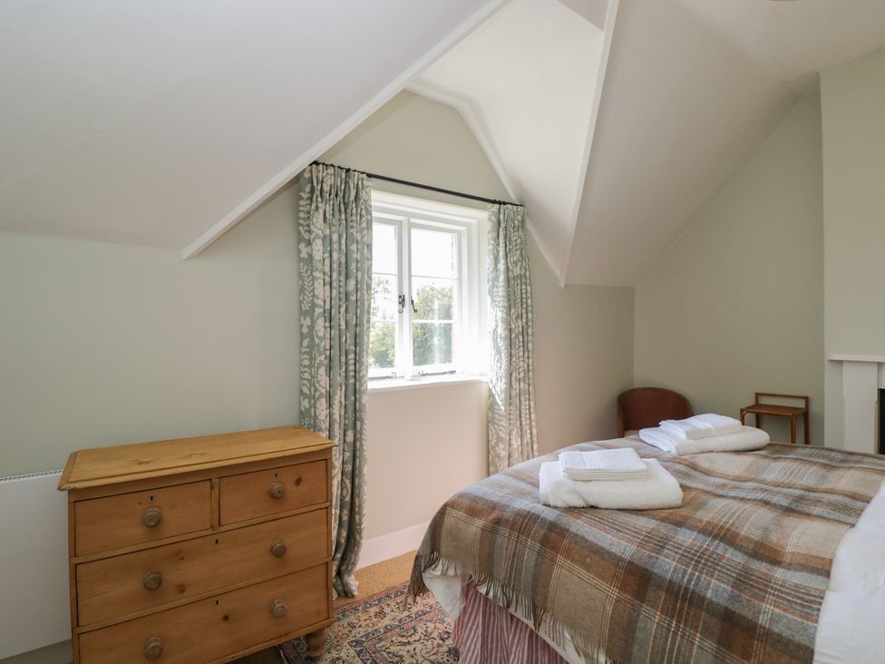 A bedroom with a bed and dresser at Middle Cottage in Tisbury, Wiltshire