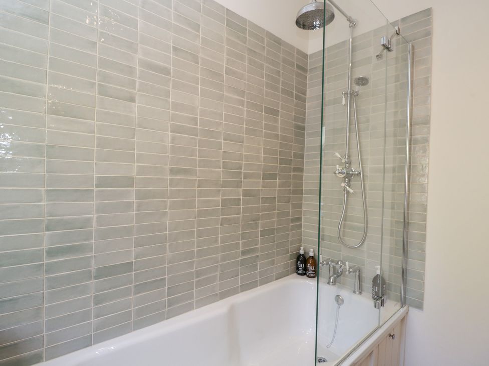 A bathroom with a bathtub and shower at Middle Cottage Tisbury, Wiltshire
