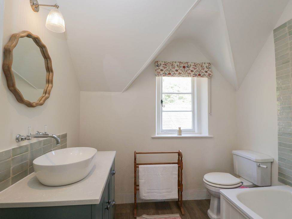 A bathroom with sink, mirror, toilet, and towel rack at Middle Cottage in Tisbury, Wiltshire