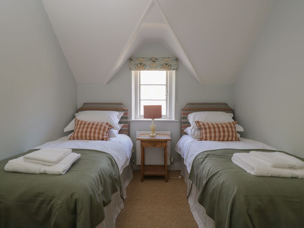 A bedroom with two single beds and a window at Middle Cottage Tisbury Wiltshire