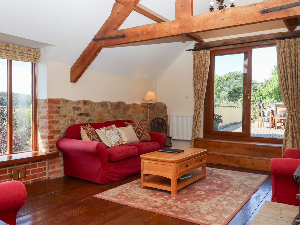 A living room with a sofa and coffee table at The Cottage in Sampford Courtenay