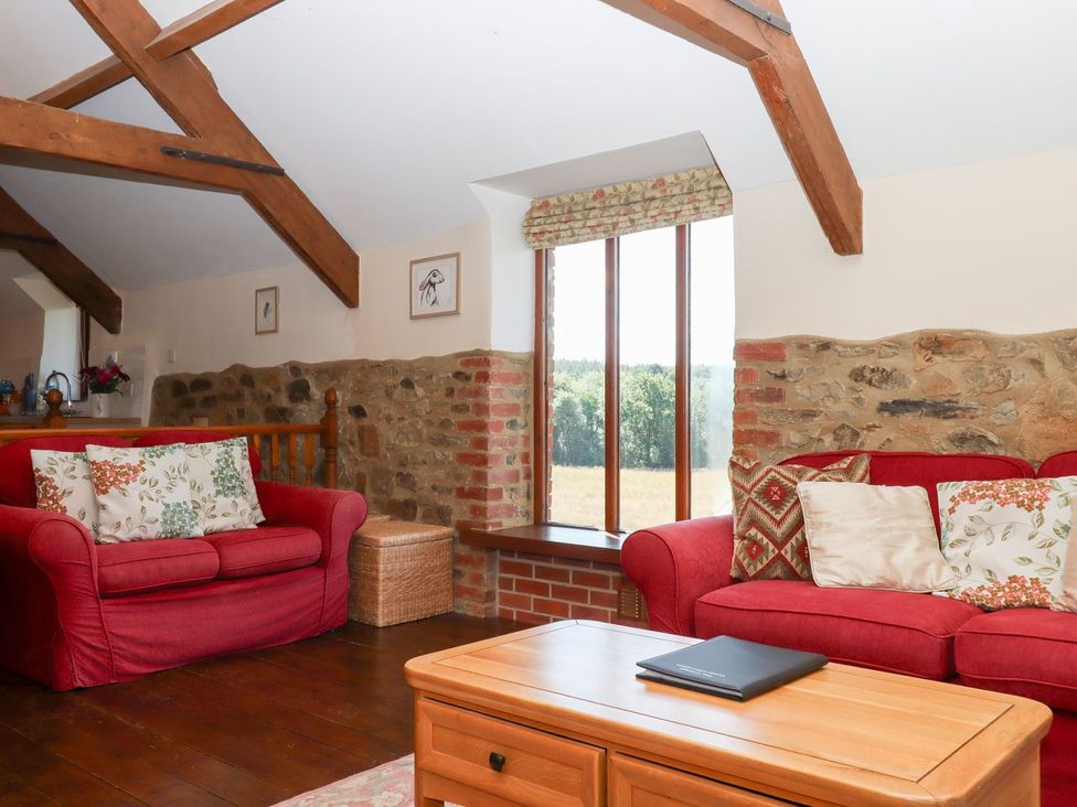 A living room with sofas and a coffee table at The Cottage in Sampford Courtenay