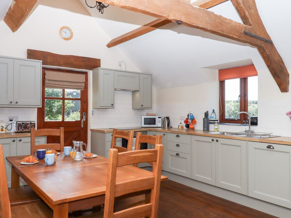 A kitchen with wooden furniture and appliances at The Cottage in Sampford Courtenay