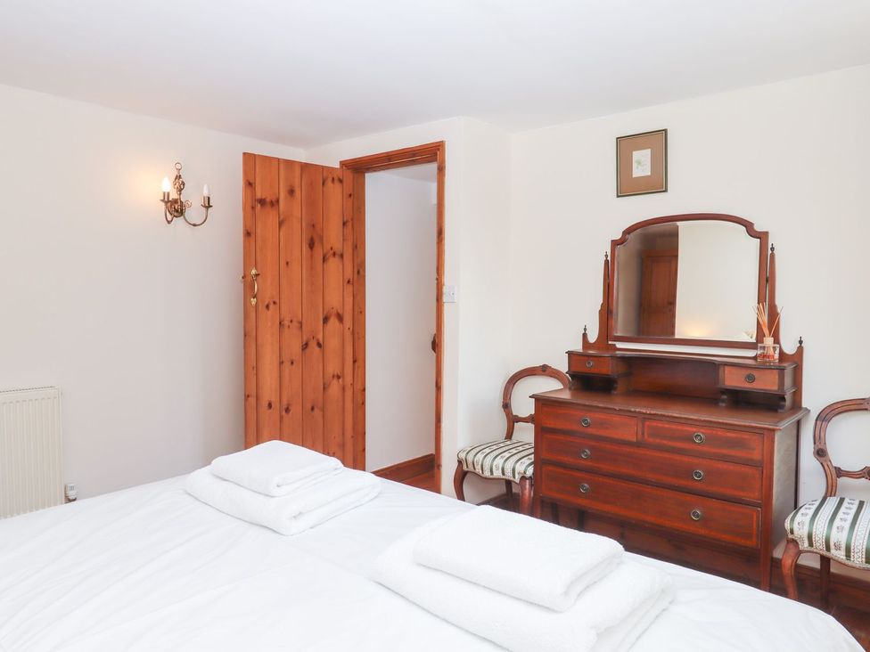 A bedroom with a bed and a chest of drawers at The Cottage in Sampford Courtenay