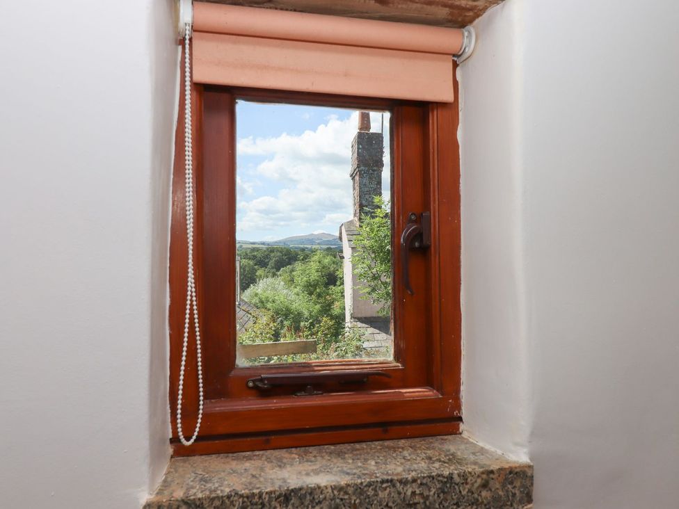 A window with a view of a chimney and landscape at The Cottage in Sampford Courtenay
