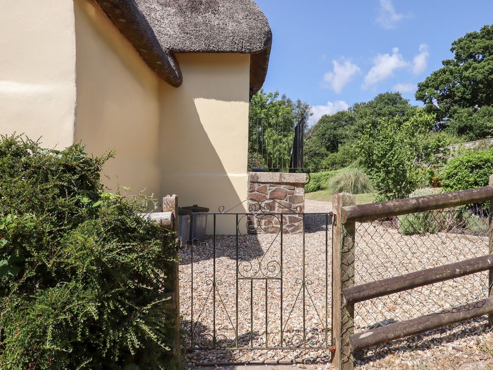 A garden area with a gate and gravel path at The Cottage in Sampford Courtenay