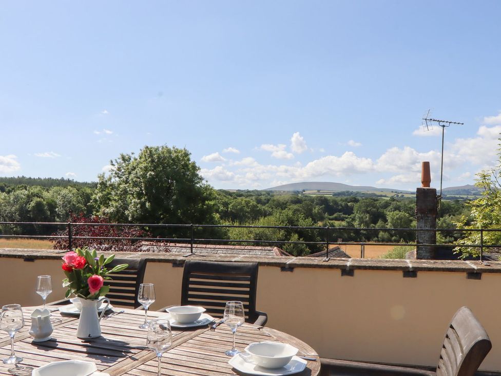 An outdoor dining area with a table and chairs at The Cottage in Sampford Courtenay
