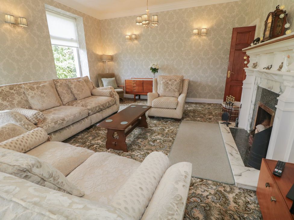 A living room with a fireplace and seating furniture at Riverdene in Mountjoy