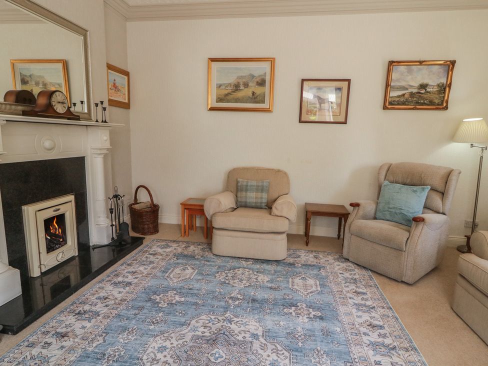 A living room with a fireplace and armchairs at Riverdene in Mountjoy
