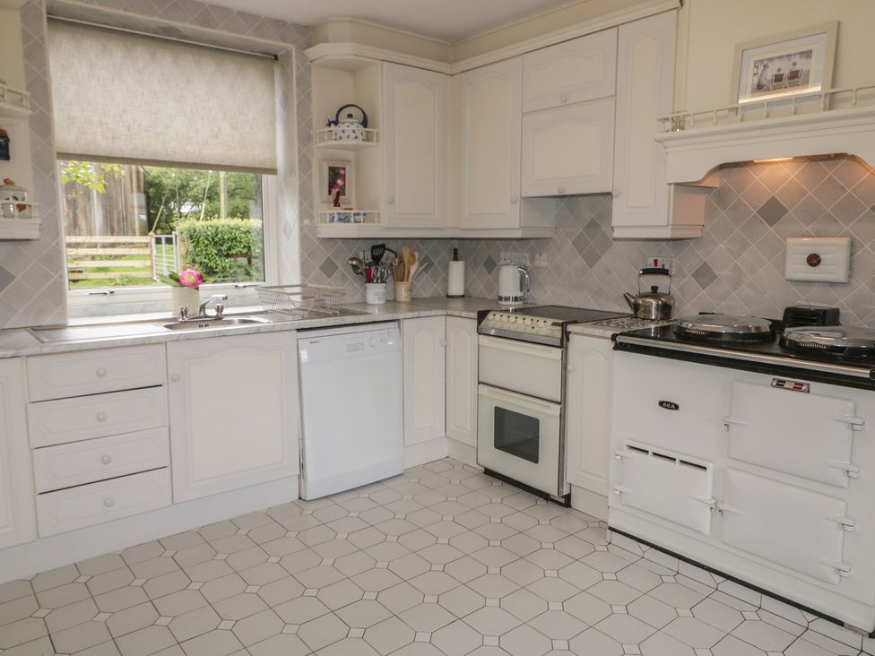 A kitchen with a sink, dishwasher, and oven at Riverdene in Mountjoy