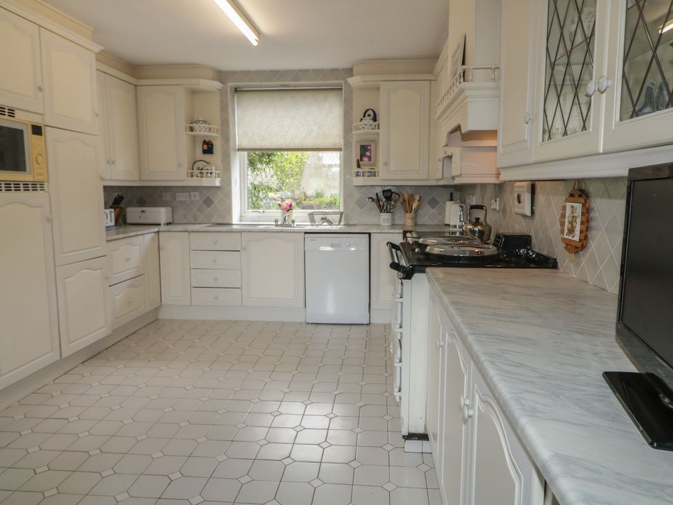 A kitchen with white cabinets and appliances at Riverdene in Mountjoy
