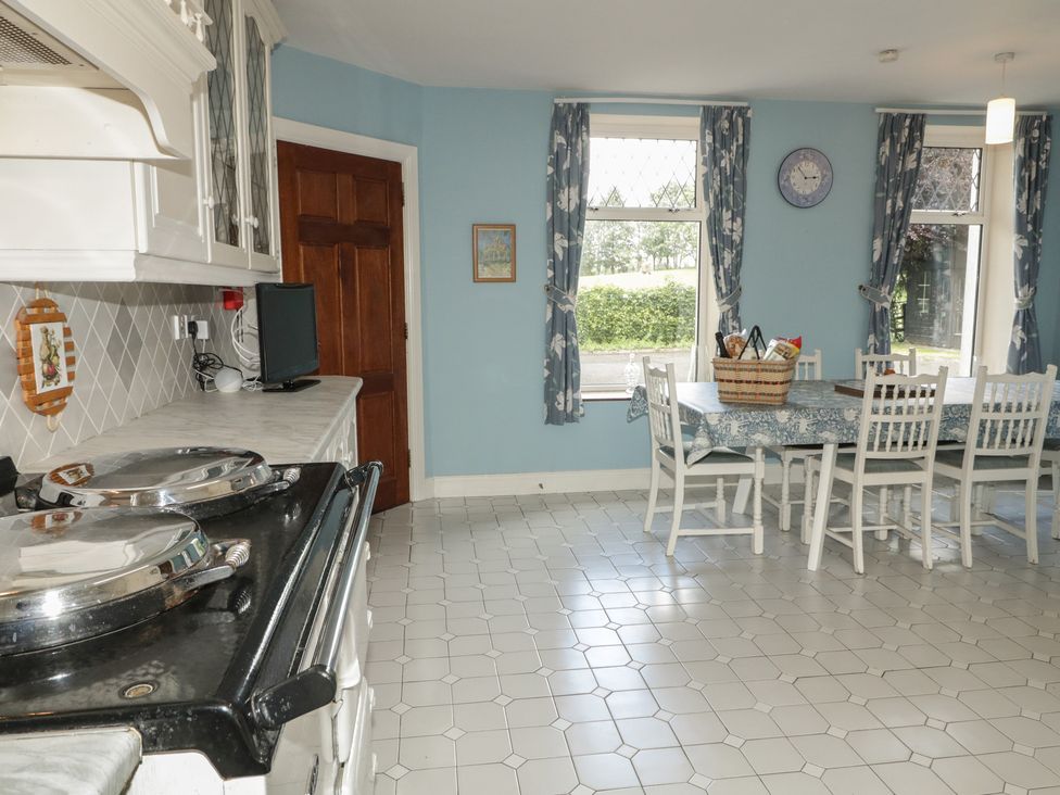 A kitchen with a stove and dining table at Riverdene in Mountjoy