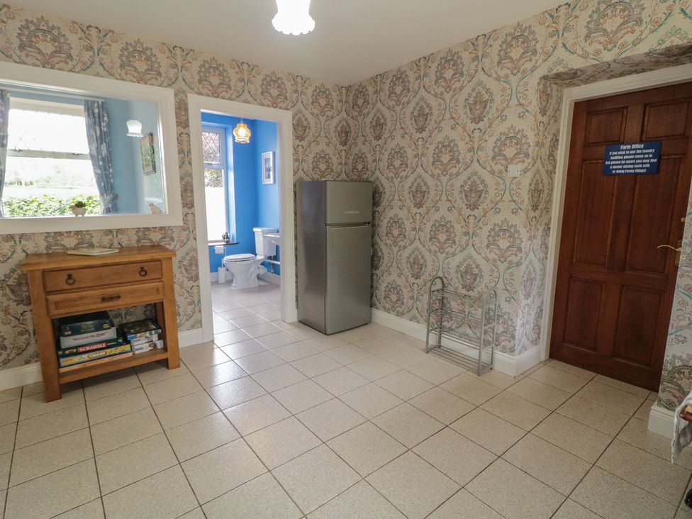 A kitchen with a refrigerator and wooden cabinet at Riverdene in Mountjoy