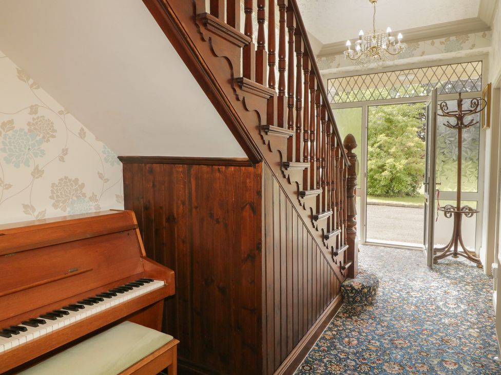 A hallway with a piano and staircase at Riverdene in Mountjoy