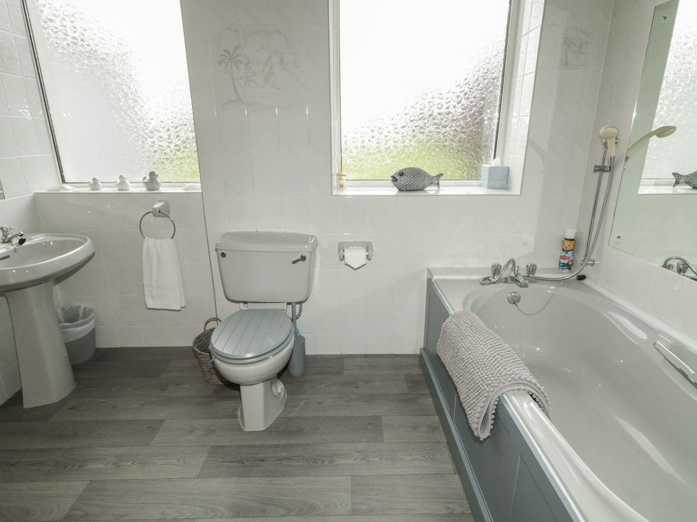 A bathroom with a bathtub, toilet, and sink at Riverdene in Mountjoy