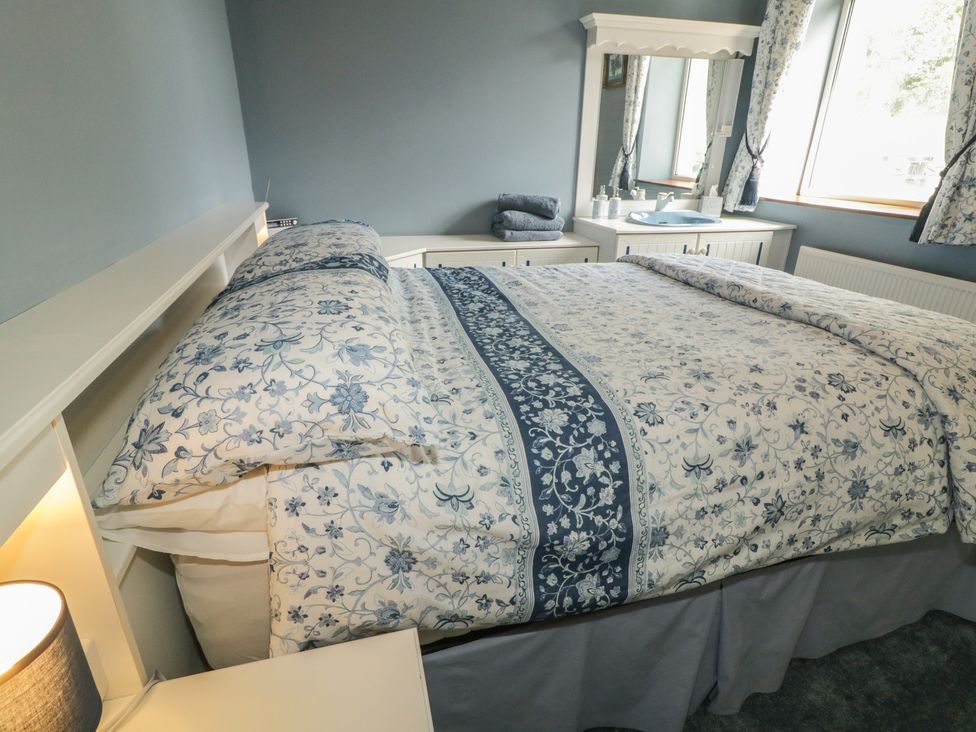 A bedroom with a bed and dressing table at Riverdene, Mountjoy