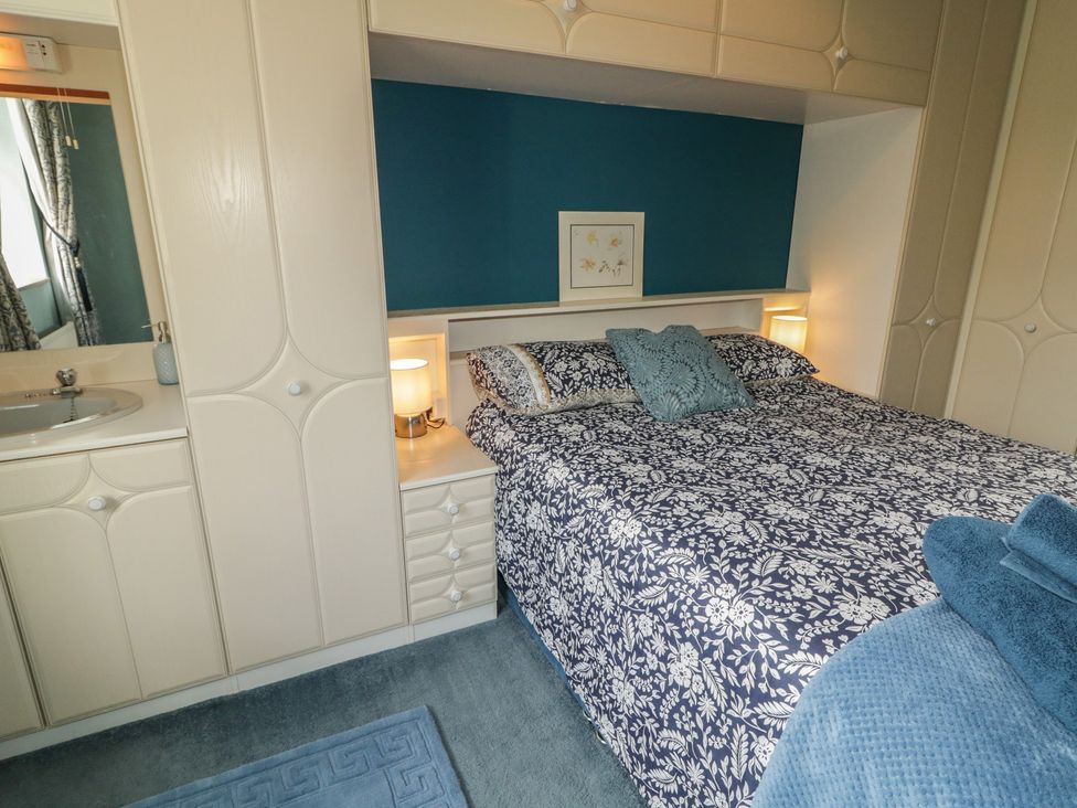 A bedroom with a bed and bedside table at Riverdene in Mountjoy