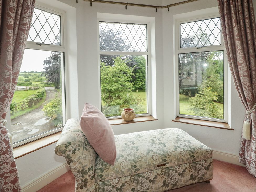 A snug room with a chaise lounge and bay windows at Riverdene in Mountjoy