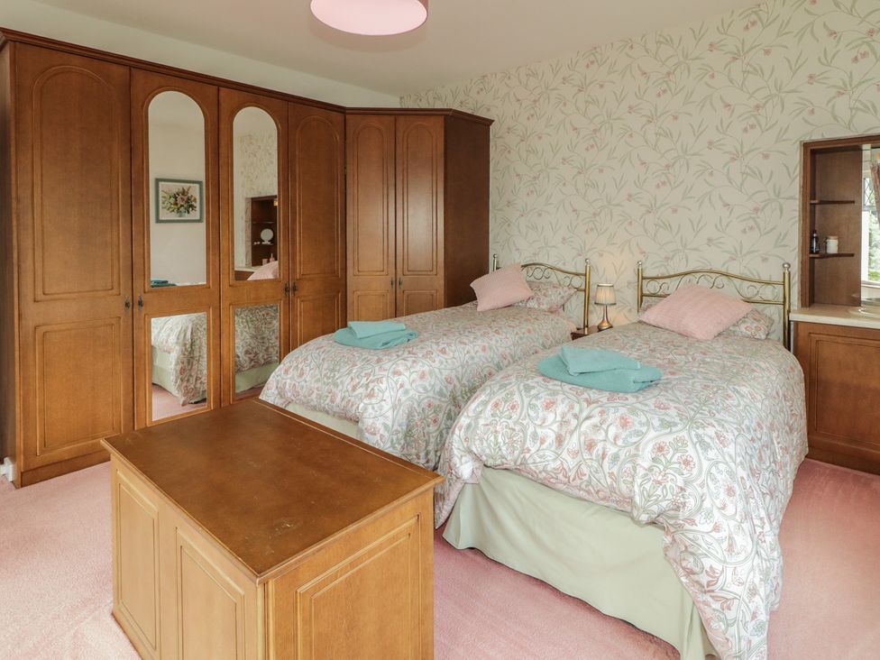 A bedroom with two beds and a wardrobe at Riverdene in Mountjoy