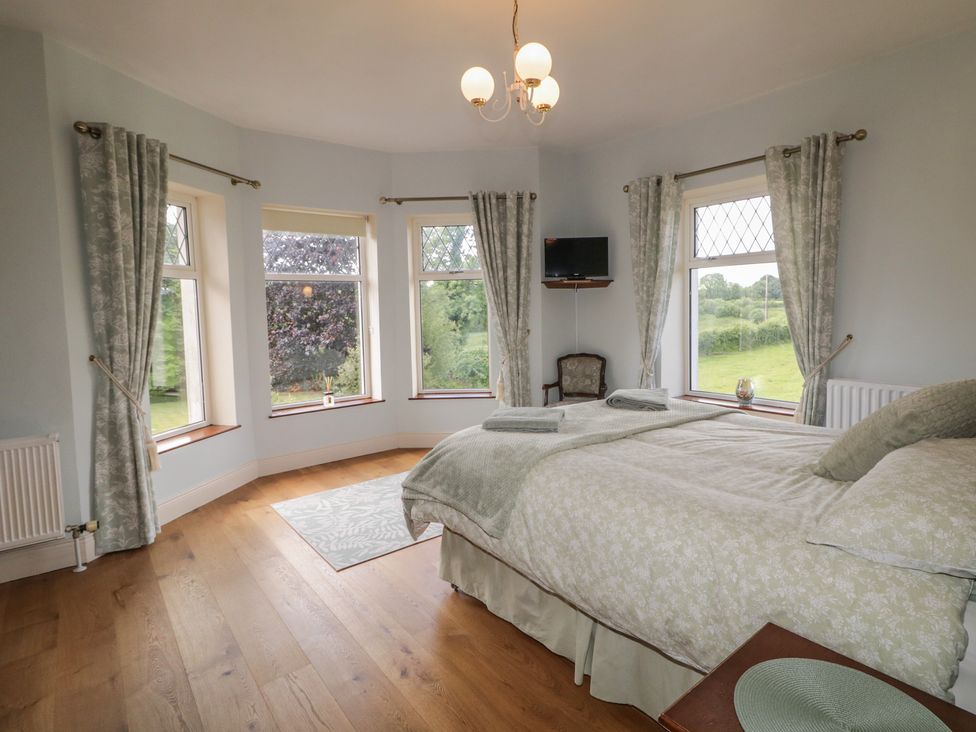 A bedroom with a bed and windows at Riverdene in Mountjoy