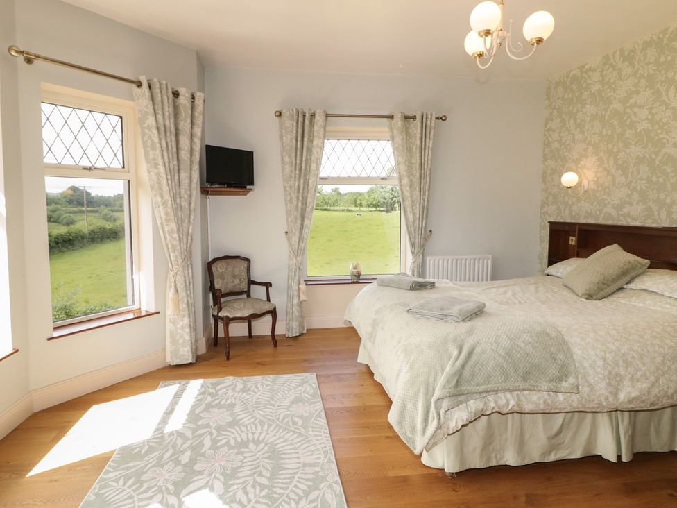 A bedroom with a bed and chair at Riverdene in Mountjoy