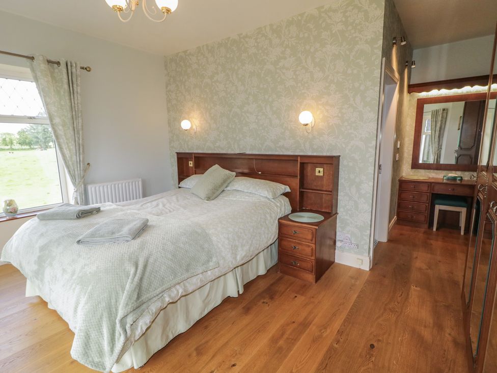 A bedroom with a bed and dressing table at Riverdene in Mountjoy