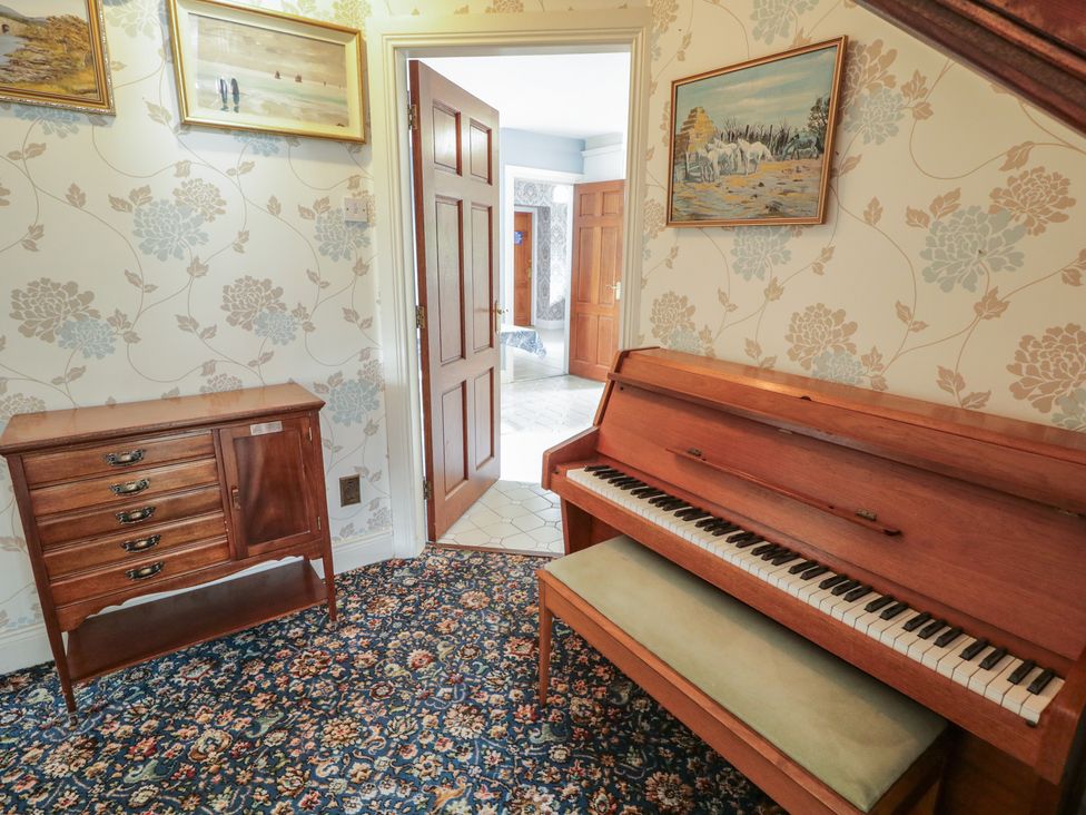 A hallway with a piano and a chest of drawers at Riverdene in Mountjoy