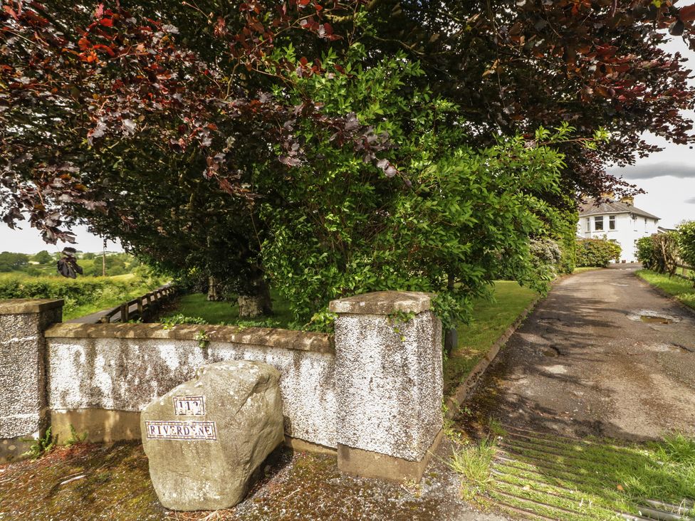 An outdoor view with a rock sign and trees at Riverdene Mountjoy