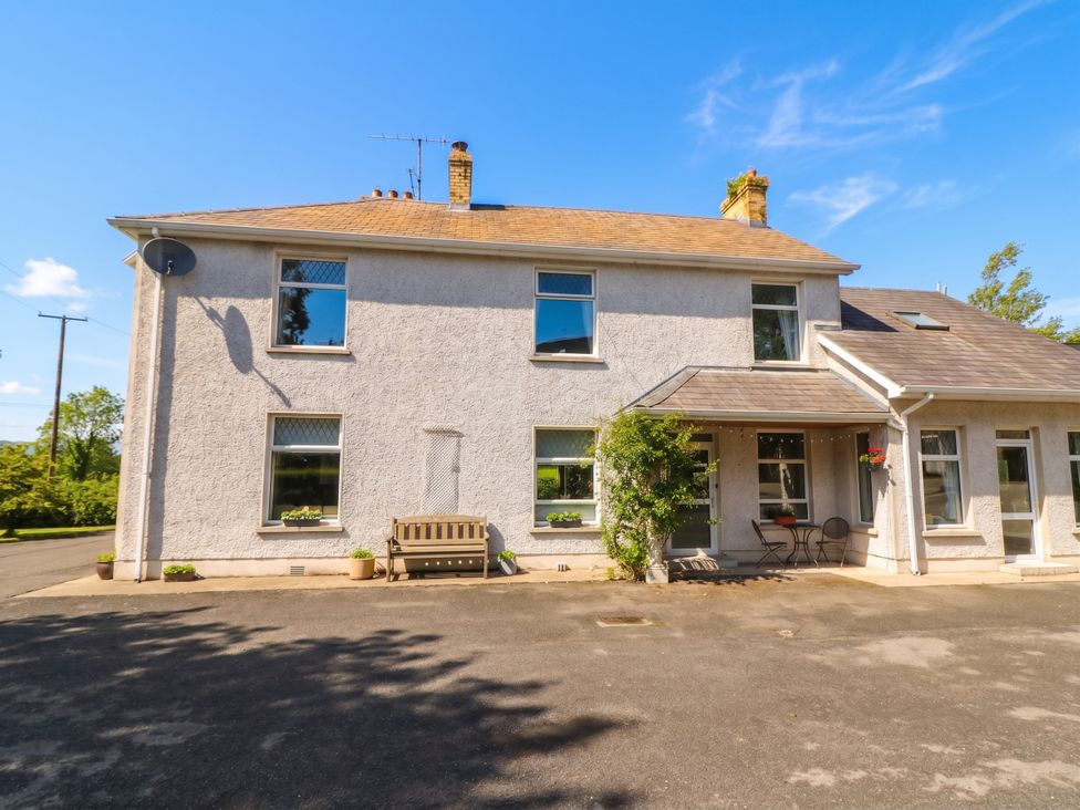 A house with a bench and chairs in front at Riverdene Mountjoy
