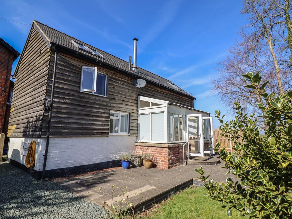 An exterior view of a house with a pathway and garden at Ystwyth Cottage in Newtown