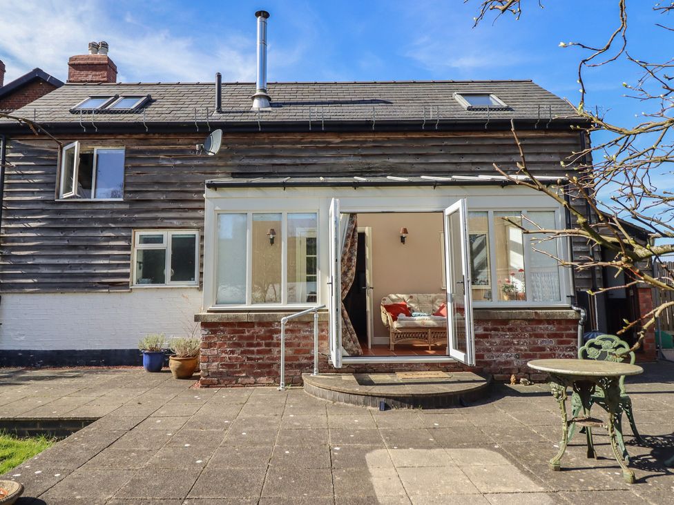 A house with glass doors opening to a patio at Ystwyth Cottage Newtown