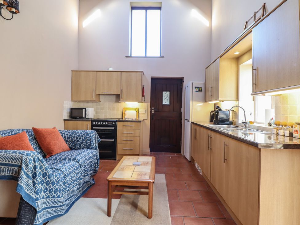 A kitchen with a sofa and table at Ystwyth Cottage in Newtown