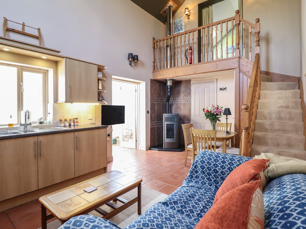 A kitchen with cabinets and a dining area at Ystwyth Cottage Newtown