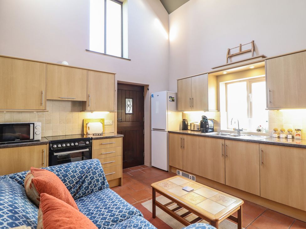 A kitchen with appliances and furniture at Ystwyth Cottage Newtown