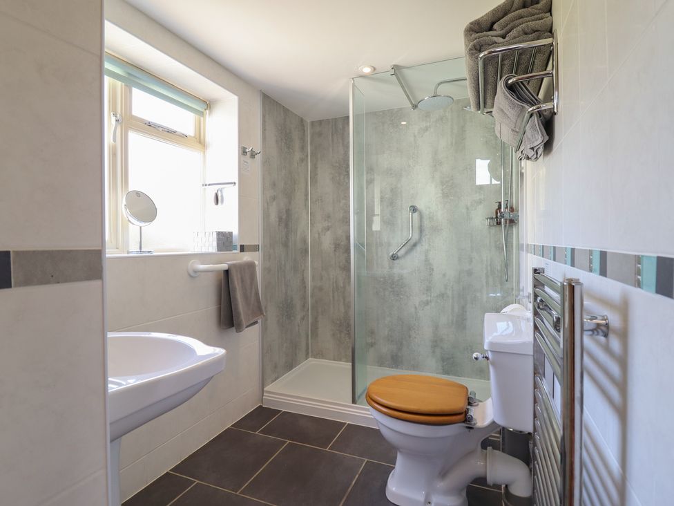 A bathroom with a shower, toilet, sink at Ystwyth Cottage in Newtown