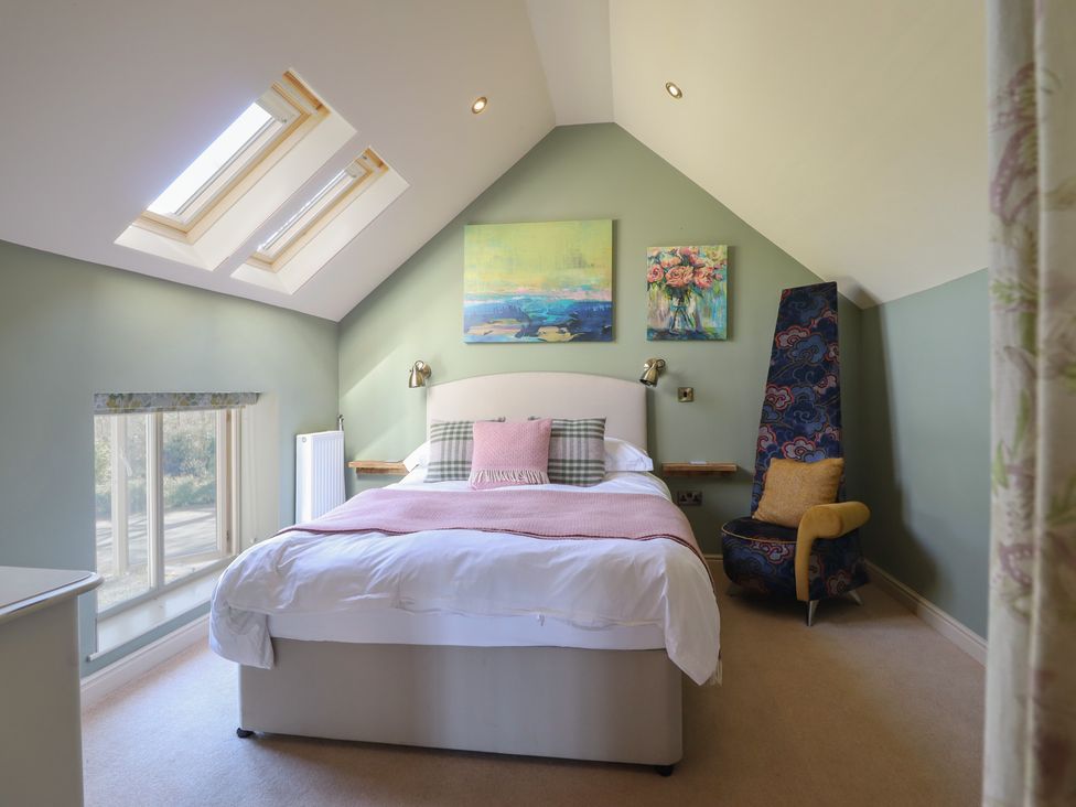 A bedroom with a bed and paintings on the wall at Ystwyth Cottage Newtown